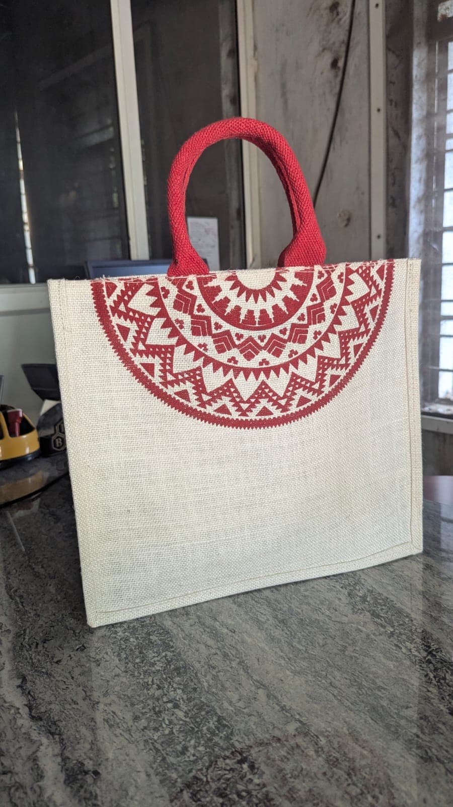 Hand-printed jute tote with bold red mandala half-circle